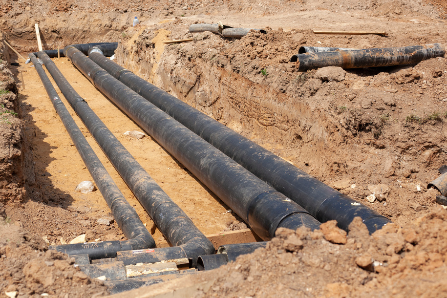 Pipes of underground utilities. Laying water pipes into the ground.